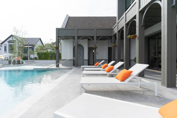 istock White loungers with orange pillow by swimming pool. 1488906041