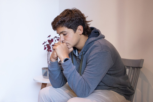 Stressed argentinean mal teenager at waiting room of a mental health office - Buenos Aires - Argentina