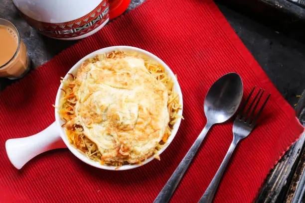 Balalet or noodles with egg omelet served in dish isolated on red mat top view on table arabic food