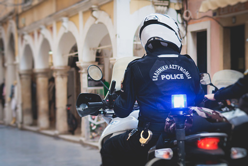 Greek police squad formation on duty riding bike and motorcycle and maintain public order in the streets of Kerkyra, Corfu, Greece, group of policemen with Greek Police logo emblem on a uniform