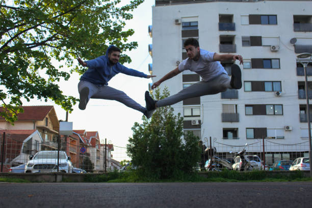 istock Two white men jumping and stretching their legs in a public park 1488910195