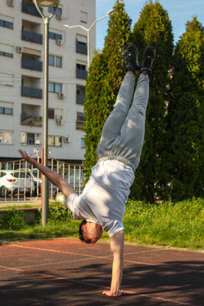 istock White man doing one hand handstand in a public park 1488911160