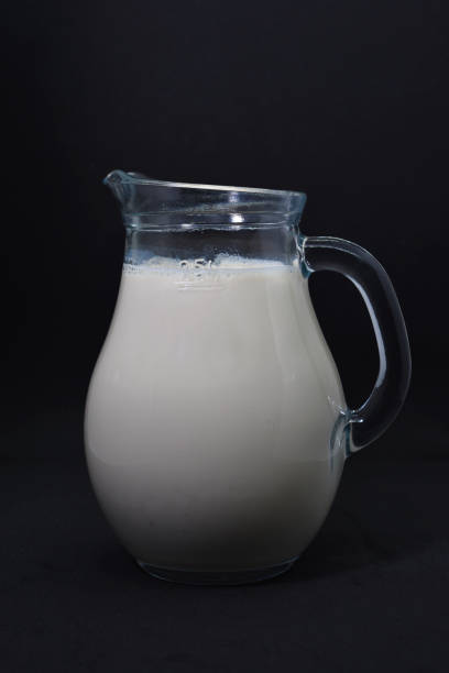 黒い背景にガラスの牛乳屋。ミルクの水差し。容器の中の牛乳。 - milk bottle bottle milk doorstep ストックフォトと画像