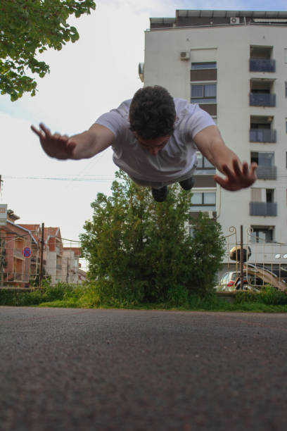 istock A white man jumping from the ground while doing a pushup in a public park 1488911333