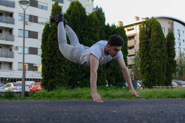 istock A white man jumping from the ground while doing a pushup in a public park 1488911414