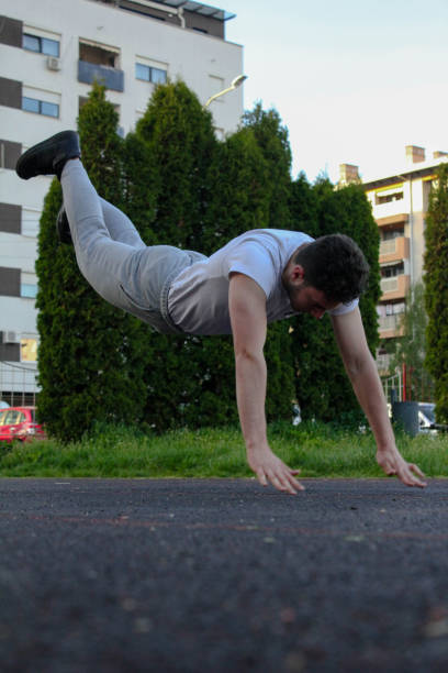 istock A white man jumping from the ground while doing a pushup in a public park 1488911440