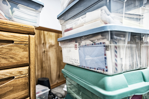 A plastic container storage box stacked in a residential home storage room is stuffed with letters received from a military veteran's Mom while he (me - the photographer) was serving on a United States Navy guided missile frigate in the early 1970's during the Vietnam War. NOTE: The partially visible address is not a personal address. That was the general FPO (Fleet Post Office) address in San Francisco, California to which all correspondence intended for active overseas US Navy military personnel had to be sent. I've removed all personal identification information, and have also included both a personal home property release and a personal self portrait release as assurance that all of this material belongs to me - the photographer/Vietnam War veteran; and also this home and all visible correspondence property owner.