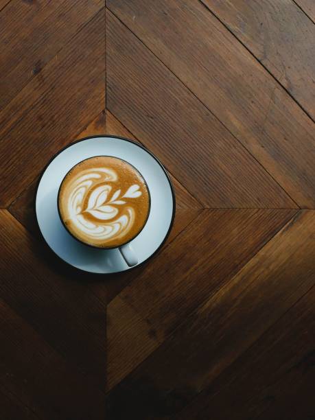 a cup of coffee on a wooden table top with a latte
