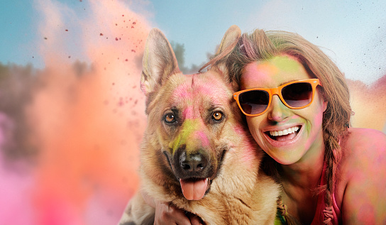 Happy woman and her furry friend having fun at festival of colors. Closeup with copy space