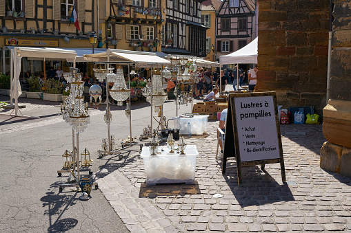 Colmar, France – September 02, 2022: Flea market with a stand for chandeliers and lamps in the old town of Colmar in France