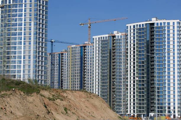 Construction site. Reinforced concrete frames of multi-storey buildings and construction cranes. The final stage of construction. Against the background of the blue sky.