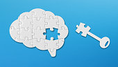 Brain shaped white jigsaw puzzle with key on blue background