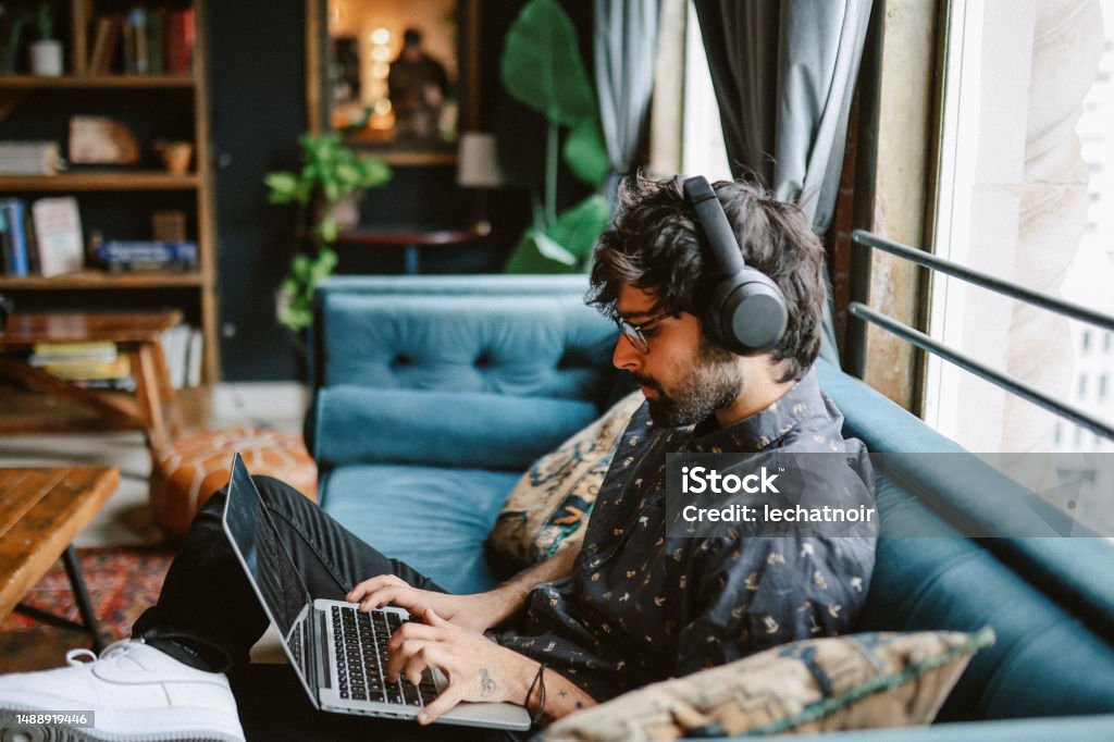 working from home in Downtown Los Angeles Young man working from home, doing IT work from his home in Los Angeles, California. Computer Programmer Stock Photo
