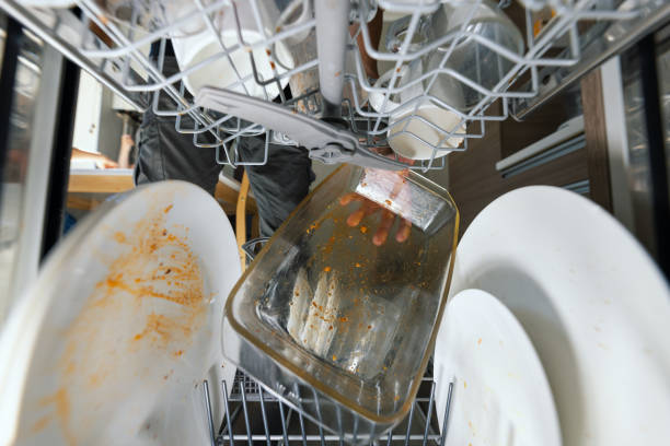 putting dirty greasy dishes into dishwasher. inside view