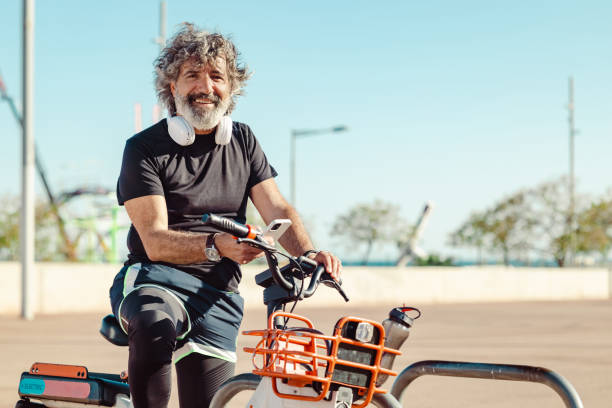istock Active senior man is sports clothes using bicycle sharing system in the city 1488925545
