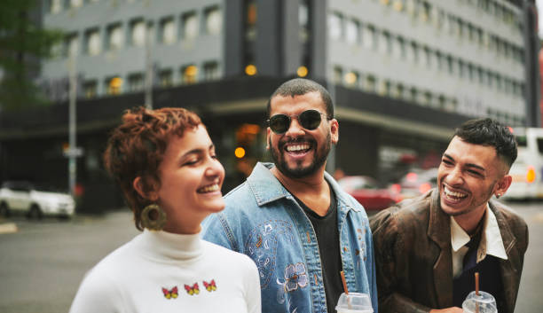 istock Young multi-ethnic non-binary and gay friends laughing while walking on a sidewalk in the city 1488926580