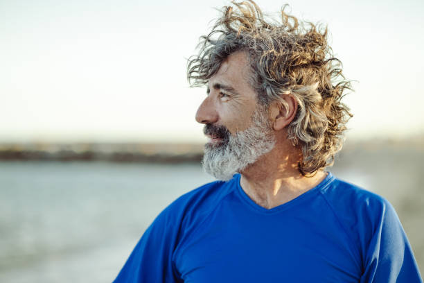 Satisfied senior man thinking at beach