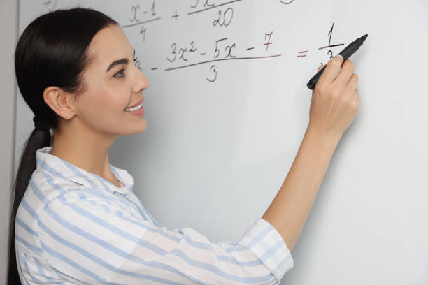 istock Happy teacher explaining mathematics at whiteboard in classroom 1488926837
