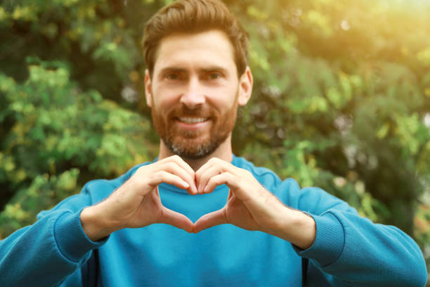 istock Happy man making heart gesture outdoors, focus on hands 1488926842