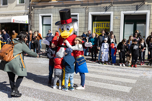 Piove di Sacco, Veneto, Italy - Mar 26th, 2023: Children celebrating with a Scrooge McDuck during a carnival parade