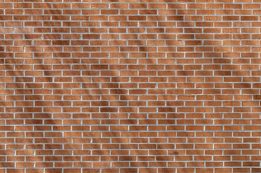 This image shows a close-up texture background of a modern traditional exterior red clay brick wall in running bond (stretcher bond) pattern, with diagonal shadows cast from angled sunlight.
