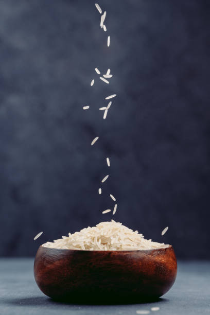 istock Grains of white rice falling into bowl 1488929575