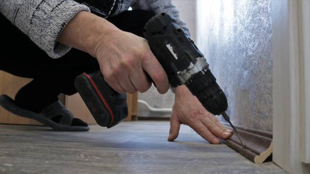istock screwing the baseboard into the room 1488931193