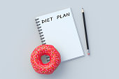 Inscription diet plan on notepad near donut and pencil. Healthy eating. Calorie control. Nutritionist consultation. Meal schedule. Slimming concept. Top view. 3d render slimming