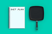 Inscription diet plan on notepad near fry pan. Healthy eating. Calorie control. Nutritionist consultation. Meal schedule. Slimming concept. Top view. 3d render slimming