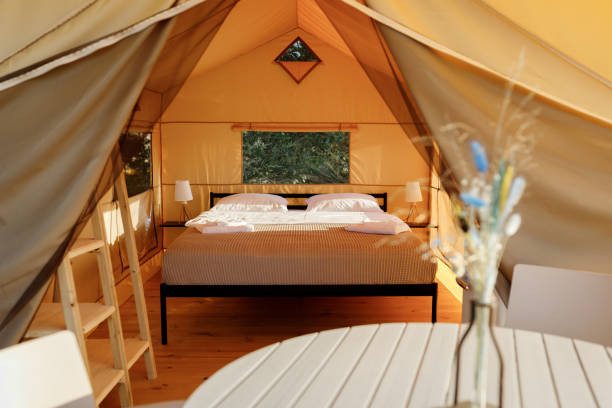 istock Interior of Cozy open glamping tent with light inside during sunset. Luxury camping tent for outdoor summer holiday and vacation. Lifestyle concept 1488932446