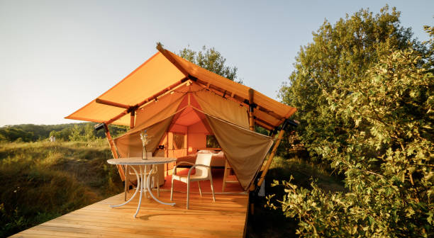 istock Cozy open glamping tent with light inside during sunset. Luxury camping tent for outdoor summer holiday and vacation. Lifestyle concept 1488932967