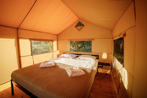 istock Interior of Cozy open glamping tent with light inside during sunset. Luxury camping tent for outdoor summer holiday and vacation. Lifestyle concept 1488932969