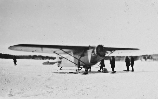 Propeller airplane with snow skis landing gear at the settlement of Sherridon on Cold Lake in Manitoba, Canada. Vintage photograph ca. 1928.