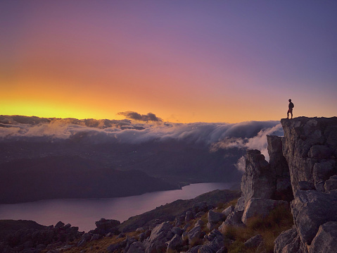 A mid aged male trail runner on top of Afrikaskop doing trail running at dawn, Franschhoek, Western Cape, South Africa