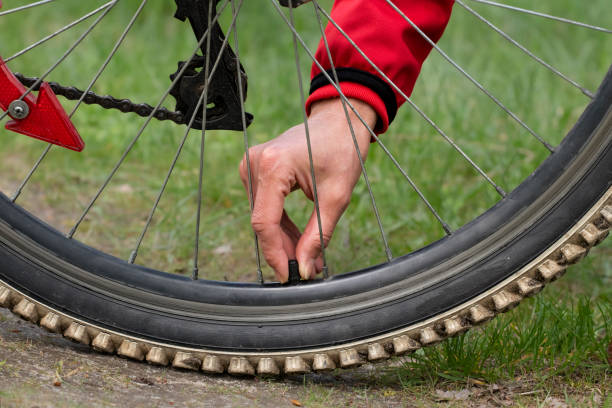 inflação da roda da bicicleta. close-up da roda da bicicleta. abra a tampa da válvula na roda. conceito de ciclismo. - bicycle bicycle pump inflating tire - fotografias e filmes do acervo