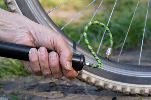 istock Man pumping bicycle wheel in the park. Man inflates bicycle wheel using a pump. 1488934801