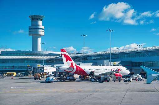 Sydney Australia March 2, 2015 Commercial Airplane Airbus A-380 in Qantas colour scheme getting towed into the Airport terminal gate at Sydney Kingsford Smith Airport. Also visible some Qantas ground grew,and some Commercial Airplanes parked, waiting for passengers to board.