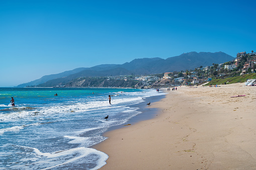 People enjoy the beach in Santa Monica, Los Angeles, California, USA on a sunny day.