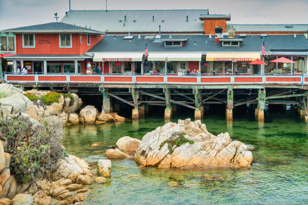 People walk at Old Fisherman's Wharf on an overcast day. It is a shopping, dining and entertainment area located at the waterfront of Monterey, California, USA.