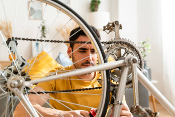istock Young man repairing a bicycle at home. 1488940651
