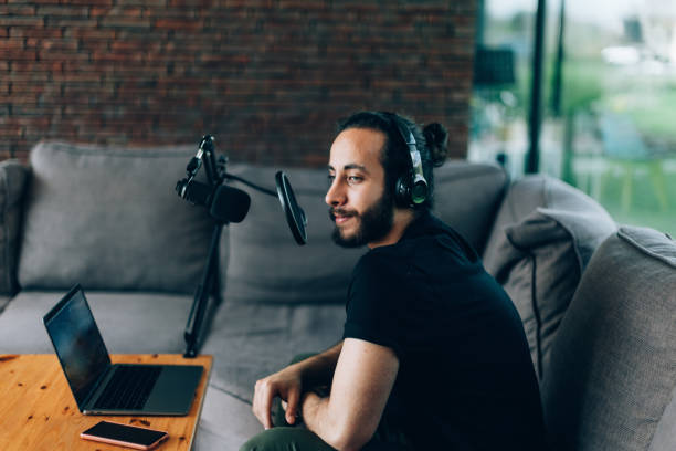 istock young man recording podcast and broadcasting from his home office 1488941423