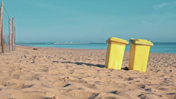 istock Yellow Plastic Dumpster Bins on Seashore Beach for Collecting Garbage during Summer Vacation Season 1488942895