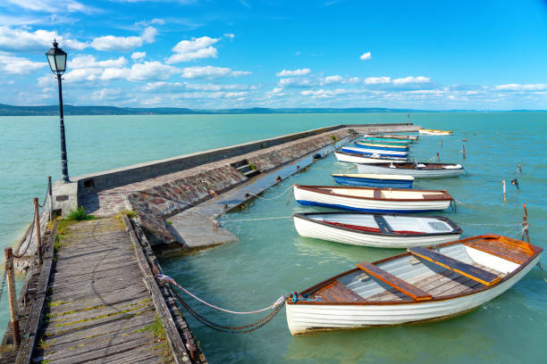 molo di legno a balatonlelle con barche colorate sul lago balaton cielo blu e acqua - beach rope nautical vessel harbor foto e immagini stock