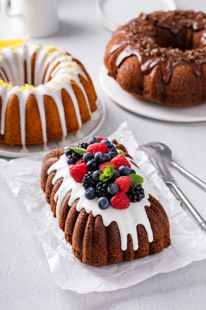 Variety of bundt cakes on the table with lemon, chocolate and berry