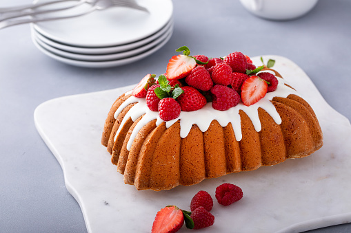 Traditional pound cake or yougurt cake topped with sugar glaze and fresh berries