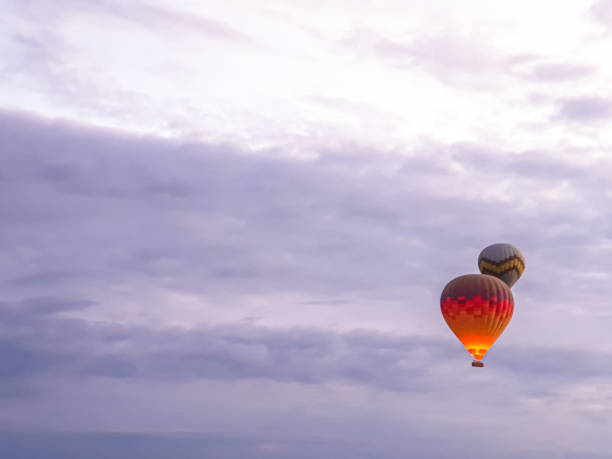 processo di lancio di molti bellissimi palloncini colorati in aria in cappadocia in montagna all'alba presto. riempimento del palloncino con aria calda dal bruciatore, preparazione del cestello. escursione, volo per i turisti sopra - cappadocia hot air balloon turkey basket foto e immagini stock