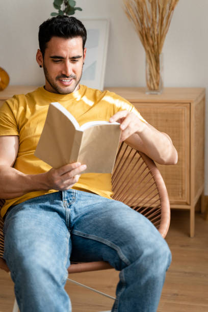 istock Relaxed man reading a book at home. 1488949811
