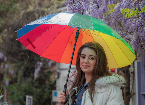 Young woman with colorful umbrella on the street