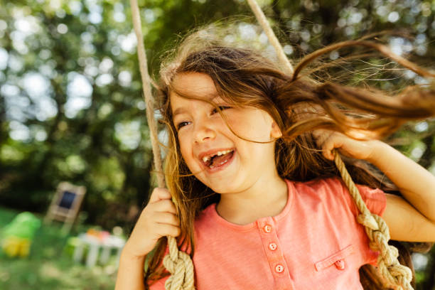 istock Smiling toothless little girl swinging 1488954741