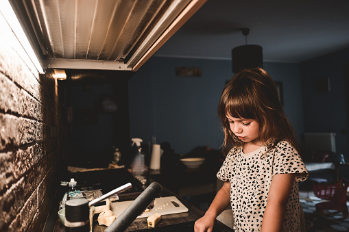 preschool child playing in a kitchen.